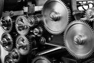 gears-cogs-machine-machinery-159298-159298 Close-up view of a complex industrial gear mechanism in black and white.